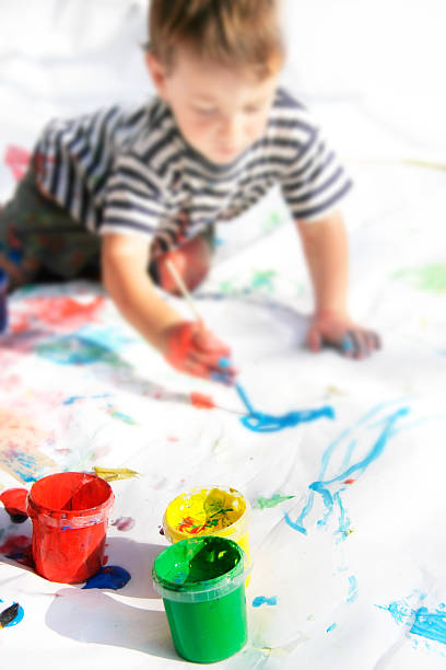 istock young boy painting, focus on cans 95627640
