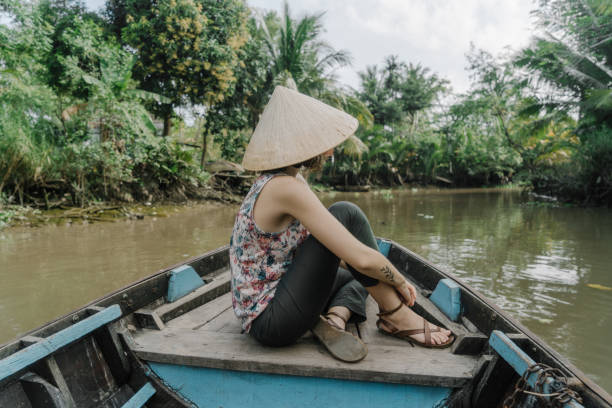 istock Woman riding on boat through Mekong delta 956277250