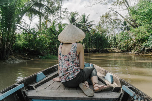 istock Woman riding on boat through Mekong delta 956277258