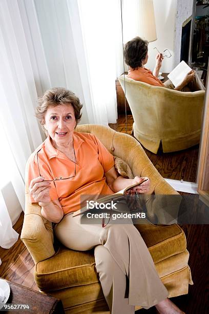 Foto de Sênior Mulher Sentada Em Casa Lendo Um Livro e mais fotos de stock de 70 anos - 70 anos, Aconchegante, Adulto