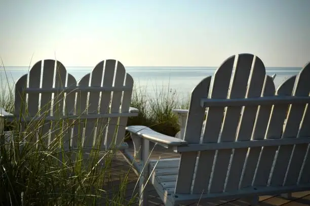 White Adirondack chairs facing Lake Michigan.