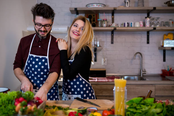 istock Smiling young couple cooking food in the kitchen 956278534