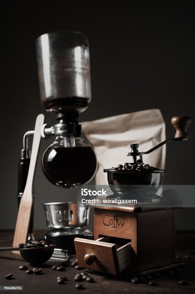 https://media.istockphoto.com/id/956286176/photo/japanese-siphon-coffee-maker-and-coffee-grinder-on-old-kitchen-table-background-it-is-very.jpg?s=1024x1024&w=is&k=20&c=5Wh5wbir2PqCK2Z9EkNude38qkJzmi94SCxaNzv3m40=
