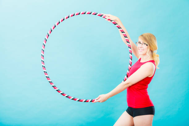 istock Fit woman with hula hoop doing exercise 956287130