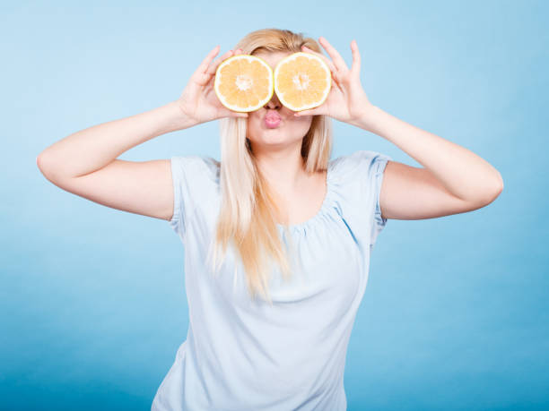 istock Girl covering her eyes with grapefruits 956287368