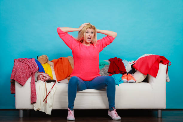 istock Woman does not know what to wear sitting on couch 956287448