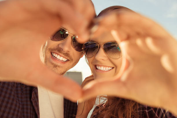 istock Cheerful romantic couple making heart gesture with hands 956292056