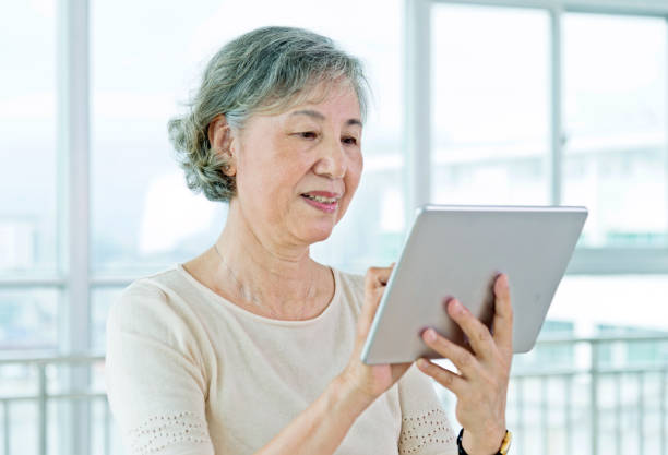 istock Asian senior woman using a digital tablet at home 956292074