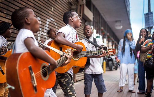 Johannesburg, South Africa, April 29-2018: Buskers playing on the streets. Kids playing guitars and singing in the city.