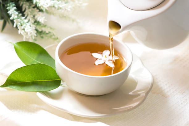 istock Close up pouring hot jasmine tea in a white tea cup ,  Tea ceremony time concept 956292654