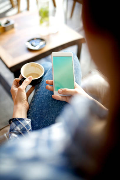 istock Woman texting and holding coffee 956302038