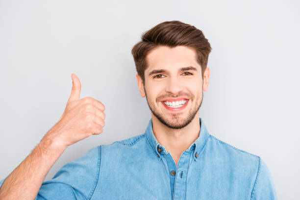 istock Happy man with beaming smile showing thumb up 956302438
