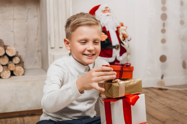 istock boy making stack of christmas gifts 956308482