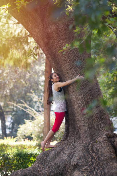 istock Young woman hugging the tree 956308622
