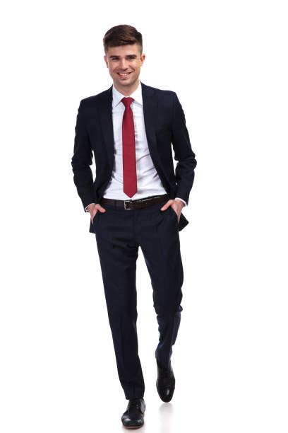 istock happy relaxed businessman with hands in pockets walking 956311602