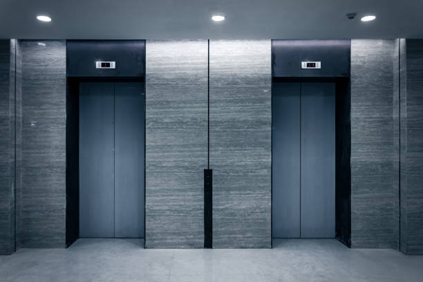 istock An empty modern elevator or lift with metal doors that are open in building with lighting. 956311780
