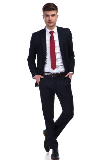 istock attractive businessman posing with hands in pockets and legs crossed 956313016