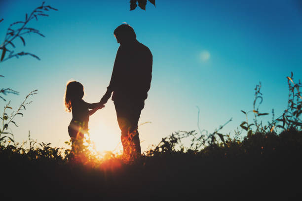 istock father with little daughter walk at sunset 956316050