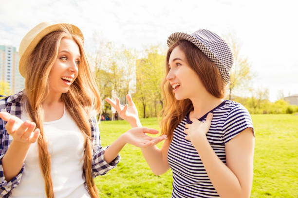 istock Two excited pretty girls having conversation in the park 956316542