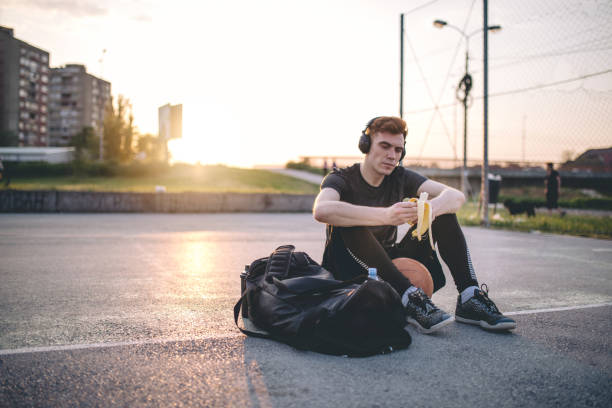istock Handsome basketball player eating a banana 956317564