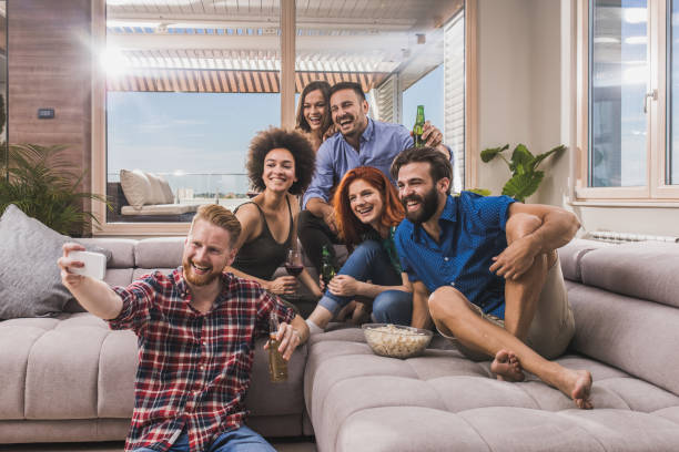 istock Happy friends having fun while taking a selfie on a home party. 956318354