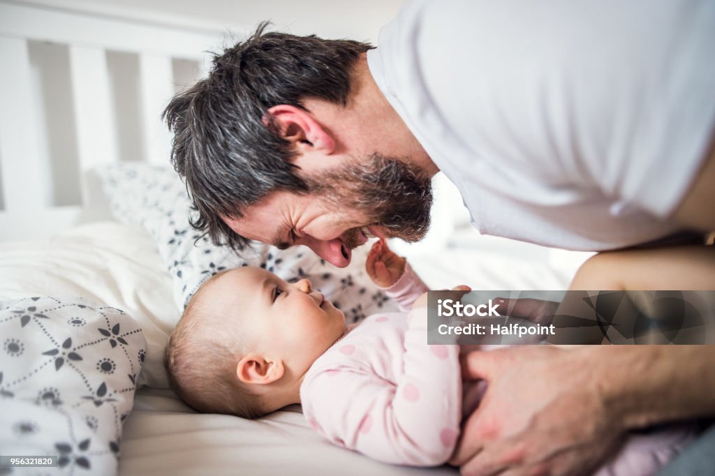 Padre con una chica de niño en cama en casa antes de acostarse. - Foto de stock de Baja por paternidad libre de derechos