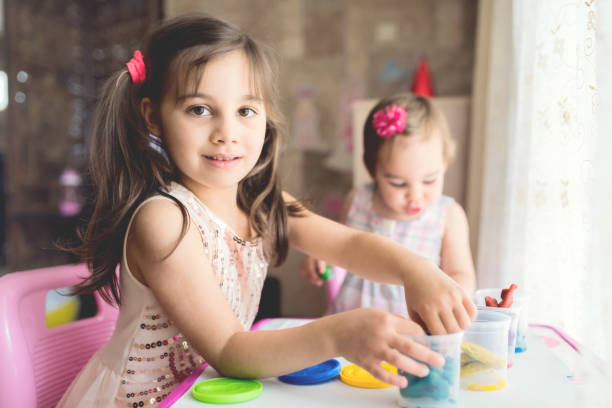 istock Little Girls Playing With Putty At Home 956321914