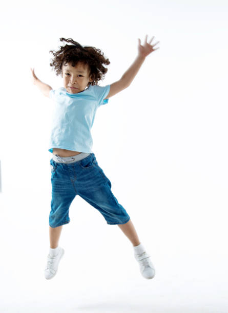 istock Little boy jumping isolated on white background 956325492