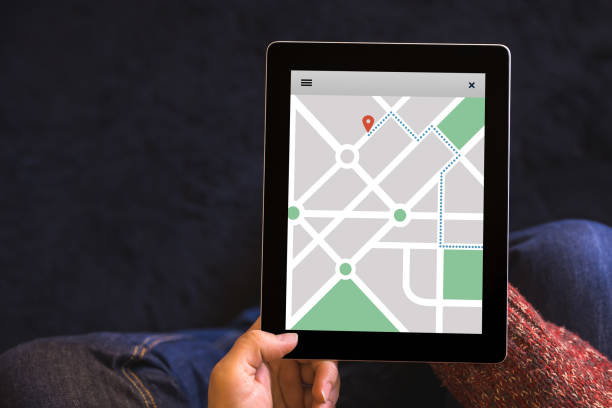 mains tenant la tablette avec emplacement concept tracker sur écran. appli de navigation gps carte - tracker photos et images de collection