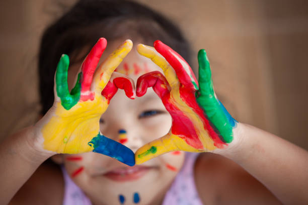 Child's hand with painted colorful watercolor make heart shape