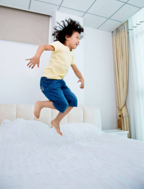 istock Little boy jumping on the bed 956329444