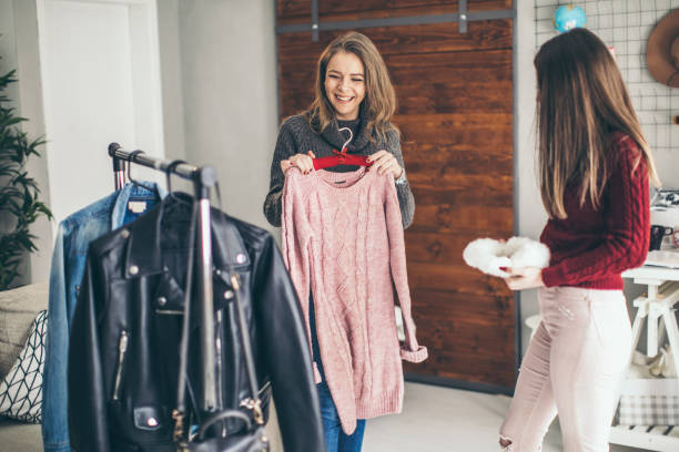 istock Two college girls try clothes 956329670