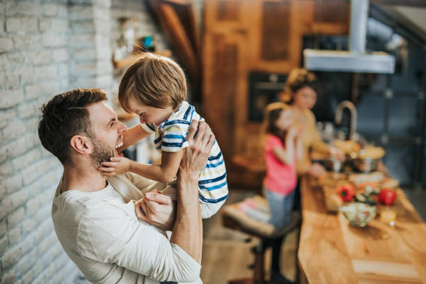 istock Cheerful father having fun while playing with his son at home. 956330156