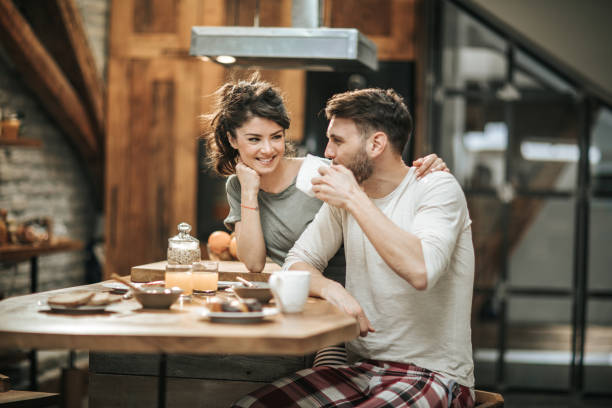 istock Embraced couple in love communicating during coffee time in the kitchen. 956332240