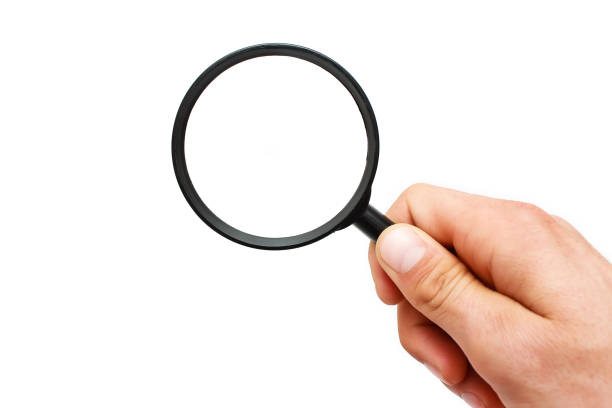 istock Male hand with a magnifying glass on a white background 956340360