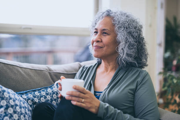istock A senior woman drinks a cup of tea by her window 956340390