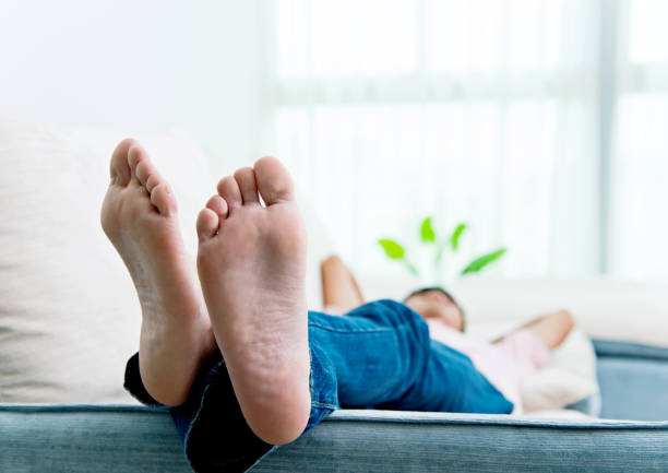 man slipping on the sofa with feet up - sole of foot imagens e fotografias de stock