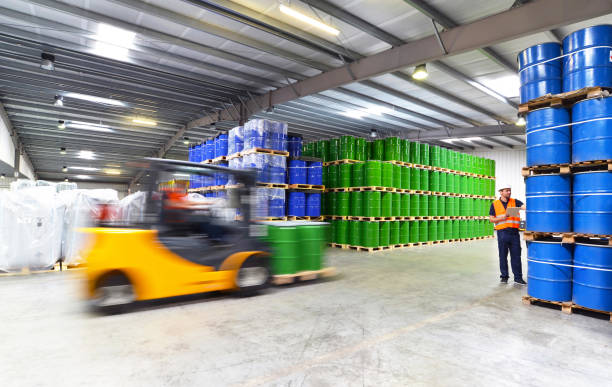 gruppo di lavoratori del settore logistico lavorano in un magazzino con prodotti chimici - camion di sollevamento - petroleum export foto e immagini stock