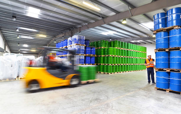 group of workers in the logistics industry work in a warehouse with chemicals - lifting truck group of workers in the logistics industry work in a warehouse with chemicals - lifting truck forklift photos stock pictures, royalty-free photos & images