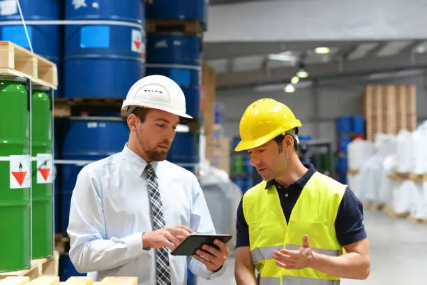 Photo of managers and workers in the logistics industry talk about working with chemicals in the warehouse