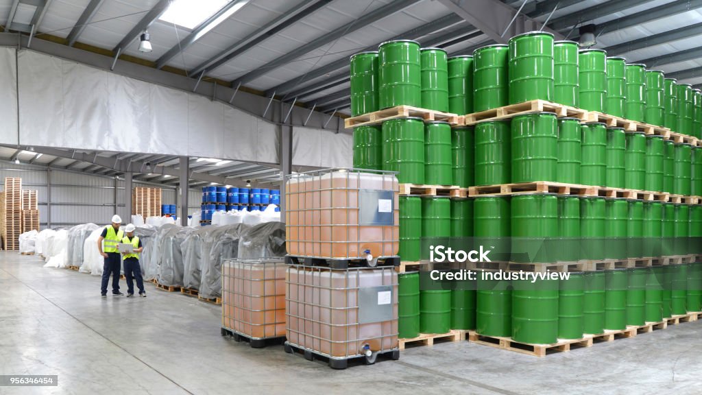 Gruppe von Arbeitern in der Logistikbranche arbeiten in einem Lager mit Chemikalien - Lizenzfrei Chemikalie Stock-Foto