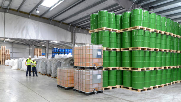 group of workers in the logistics industry work in a warehouse with chemicals - storage tank imagens e fotografias de stock