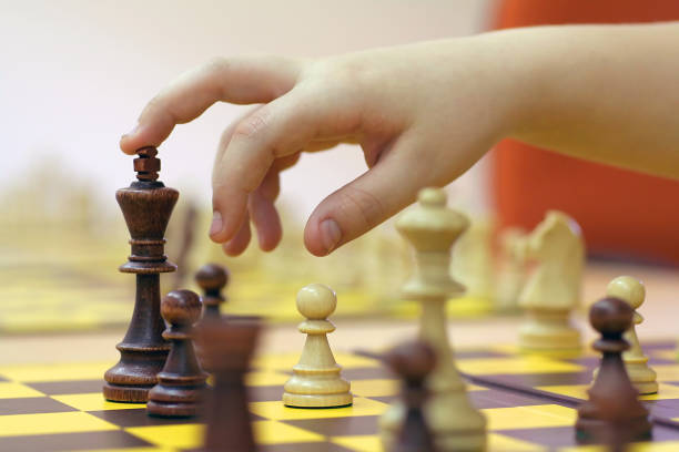 istock hand suspended over the figure of chess 956346564