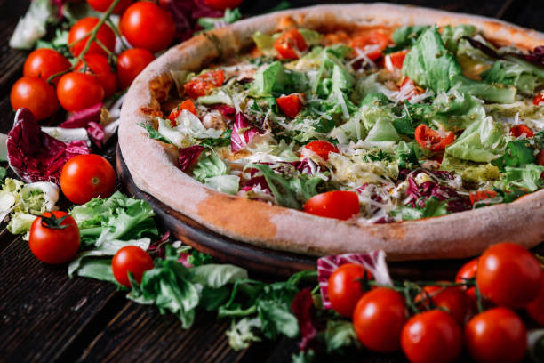 istock Pizza with chicken, salad and chery tomatoes on wood background 956347788