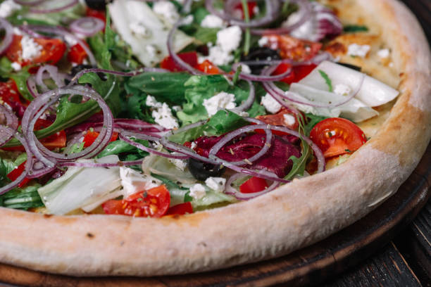 istock Whole vegeterian pizza on dark wood background. 956347972