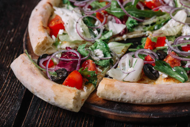 istock Sliced vegeterian pizza on dark wood background 956348030