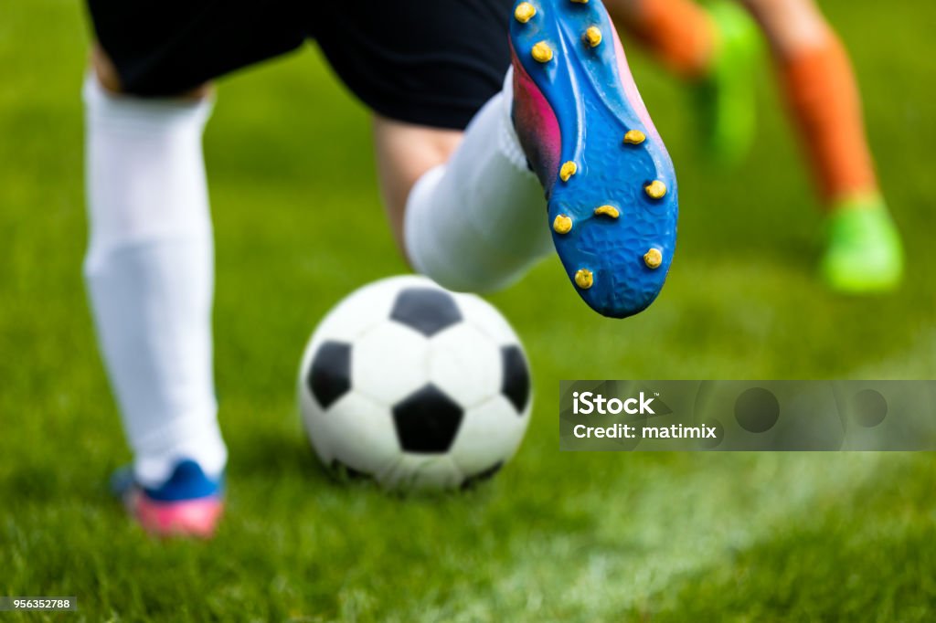 Soccer Kick. Footballer Kicking Ball on Grass Pitch. Football Soccer Player Hits a Ball. Soccer Boots Close Up Soccer Stock Photo