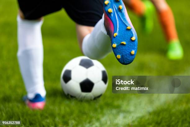 Soccer Kick Footballer Kicking Ball On Grass Pitch Football Soccer Player Hits A Ball Soccer Boots Close Up Stock Photo - Download Image Now