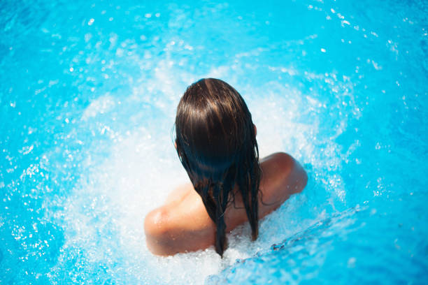 istock Beautiful woman in a swimming pool 956353522