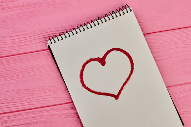 istock Heart drawn with red lipstick on paper notepad. 956353844